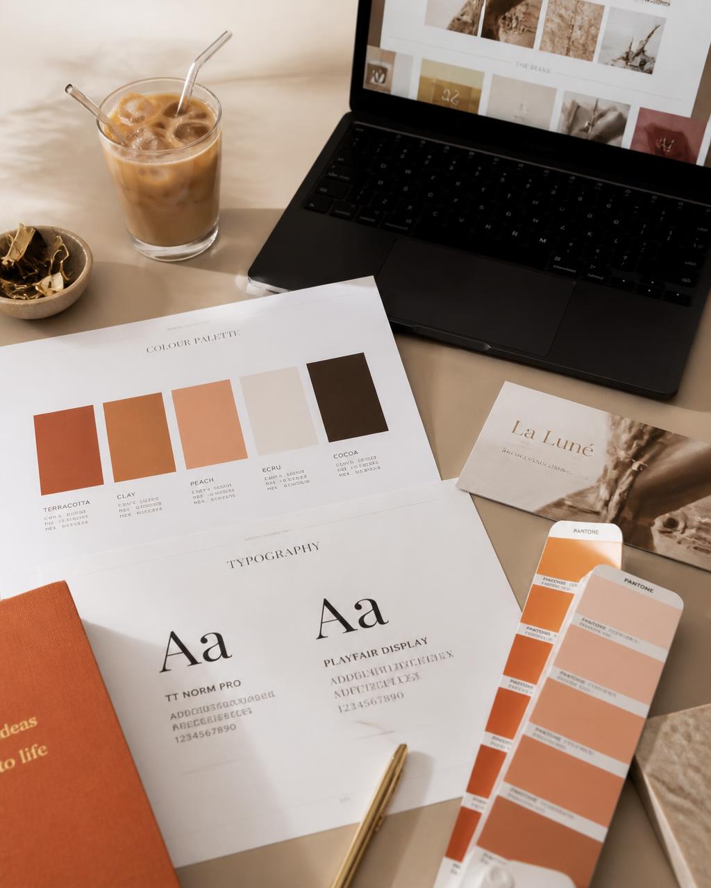 Brand guideline printouts with colour palette and typography